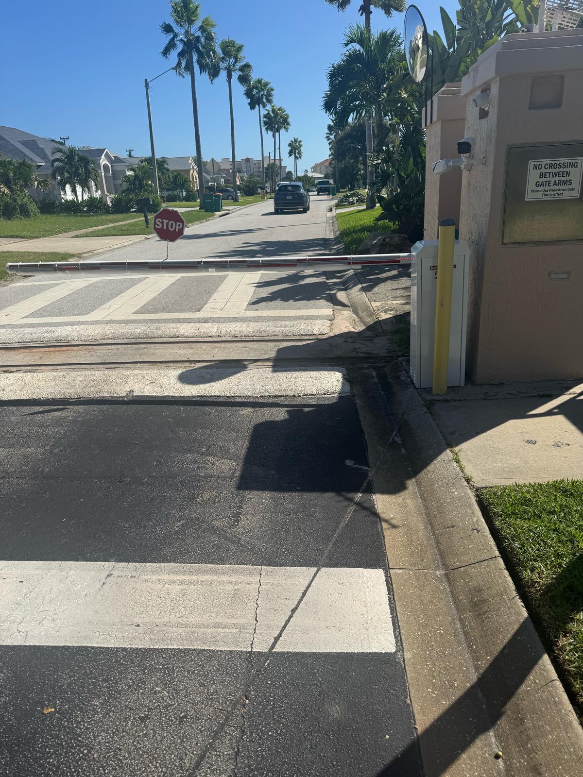 LiftMaster barrier arm gate with cameras on the entry pillar at a community entrance