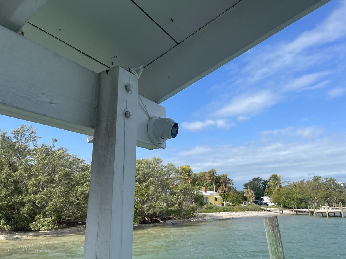 Turret security camera mounted under a waterfront dock roof